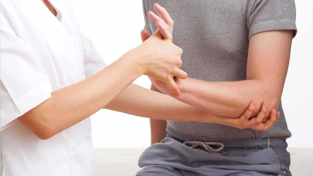 arts die een hand met artritis onderzoekt